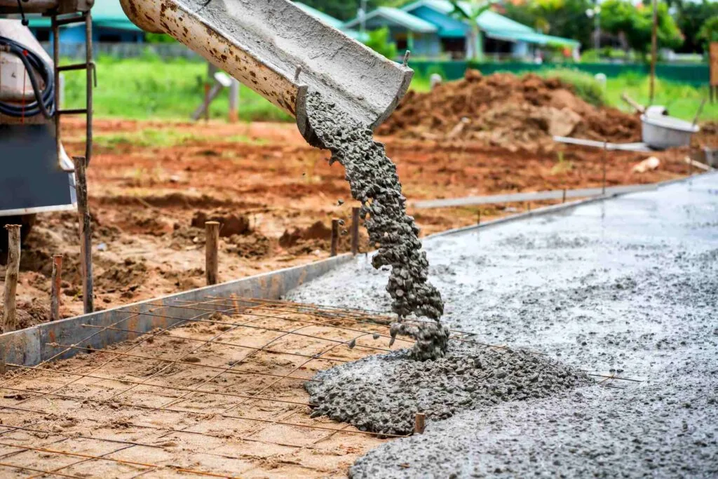 wet concrete paving sliding out of a concrete truck onto the project area
