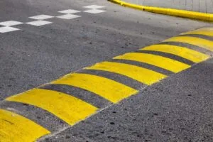 speed bump installation with bright yellow paint painted on it for visibility in parking lot