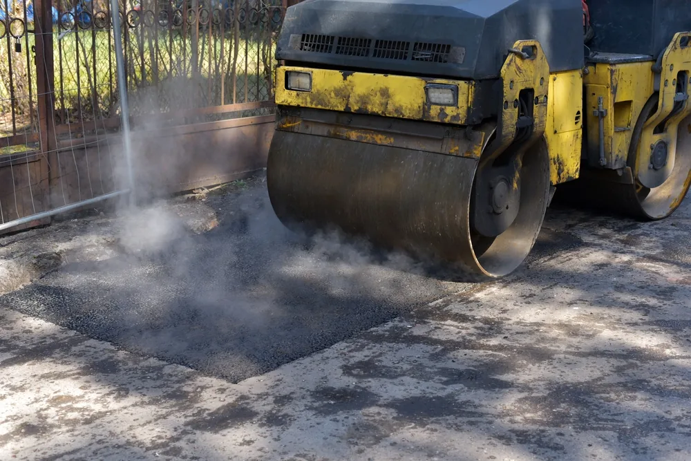 asphalt patching techniques being performed by a large machine