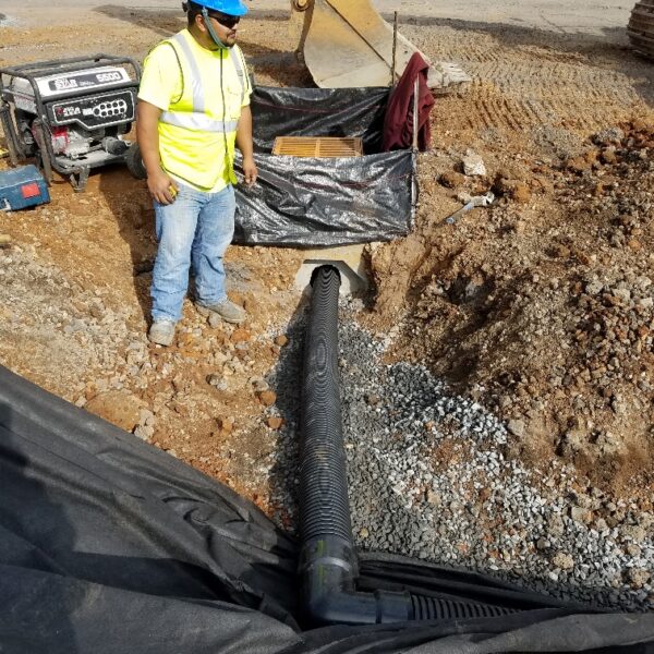 Carolina Asphalt worker is seen standing next to underground utility lines.