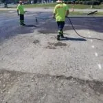Carolina Asphalt crew applying sealcoating to a commercial parking lot