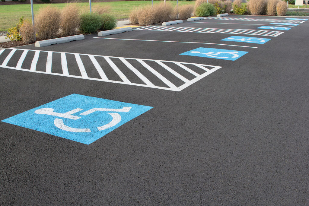 Handicapped Parking Space with fresh asphalt paving and ADA compliant striping in a parking lot