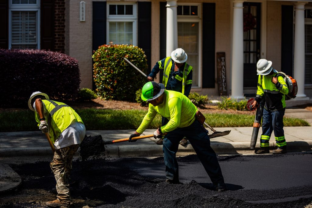 four construction workers working on the road