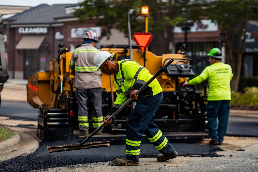 three carolina asphalt workers paving crossroads