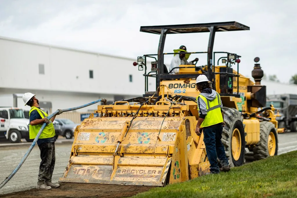carolina asphalt paving machine wiht multiple workers on a dirt road during a full depth reclamation project in charlotte, nc