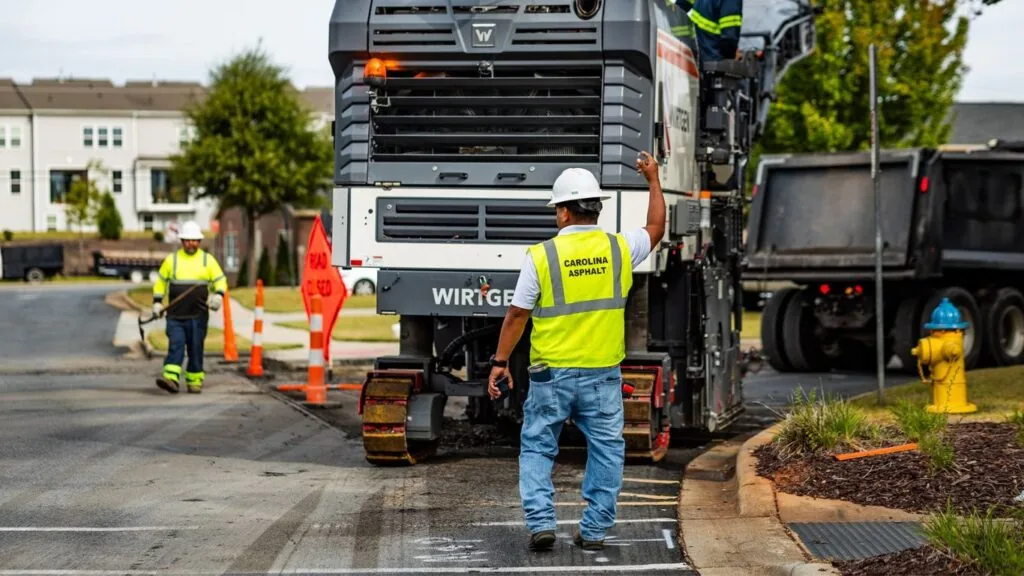 Asphalt sealcoating contractor directing crew on a Charlotte NC commercial project