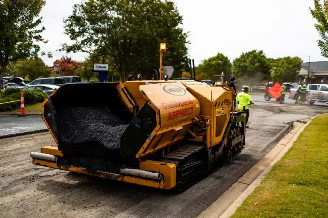 asphalt milling machine with carolina line asphalt logo sitting on freshly milled asphalt paving