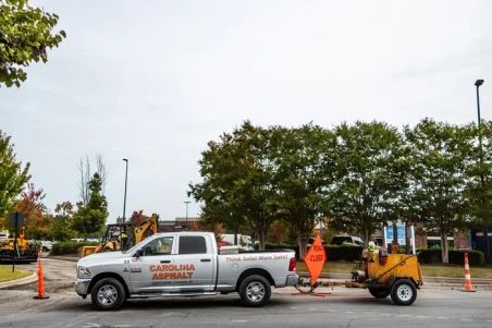carolina asphalt pick up truck with a asphalt sealcoating machine hitched to the back