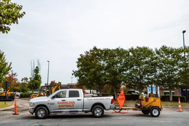 carolina asphalt pick up truck with a asphalt sealcoating machine hitched to the back