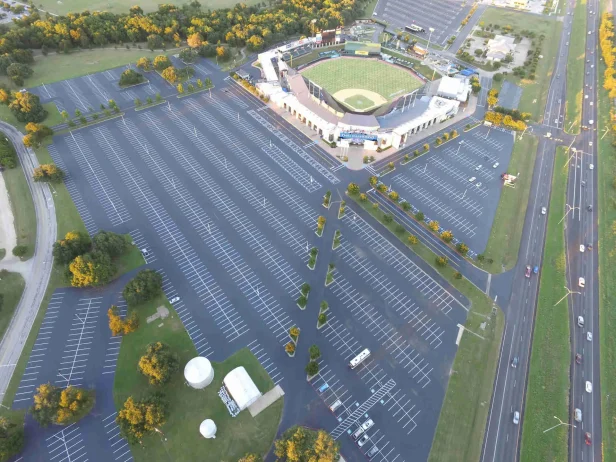 aerial view of a large parking lot with parking lot striping, sealcoating and milling work done outside of a baseball stadium in north carolina