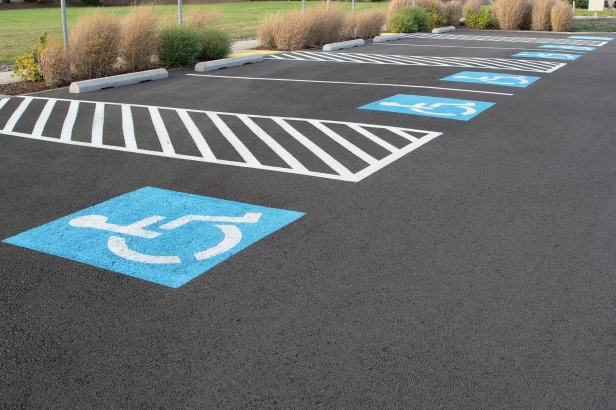 Handicapped Parking Space with fresh asphalt paving and ADA compliant striping in a parking lot